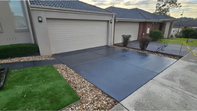 Melbourne Property Preparers after photo of newly paved dark concrete driveways in Melbourne with decorative gravel garden beds artificial turf and modern residential frontage for improved property presentation