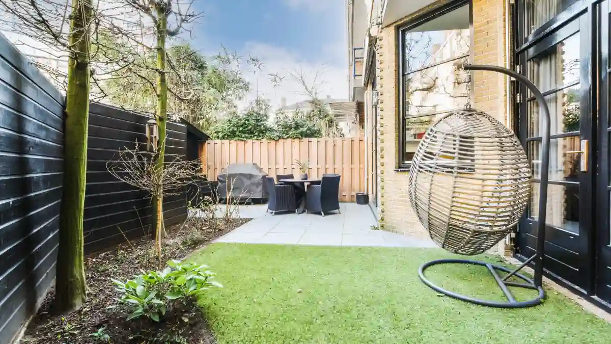 Melbourne Property Preparers after photo of landscaped backyard in Melbourne with artificial lawn garden beds young plants patio dining area and hanging egg chair for improved outdoor presentation