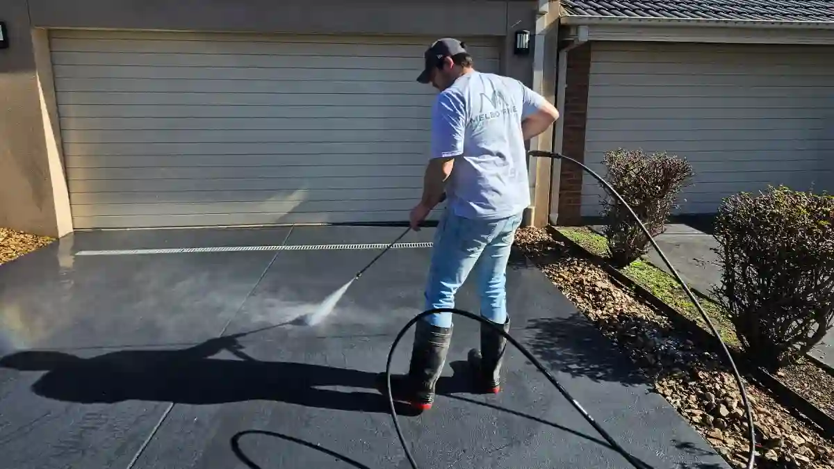 Melbourne Property Preparers team member pressure washing concrete driveway in Melbourne to remove dirt and grime and enhance curb appeal during residential property maintenance